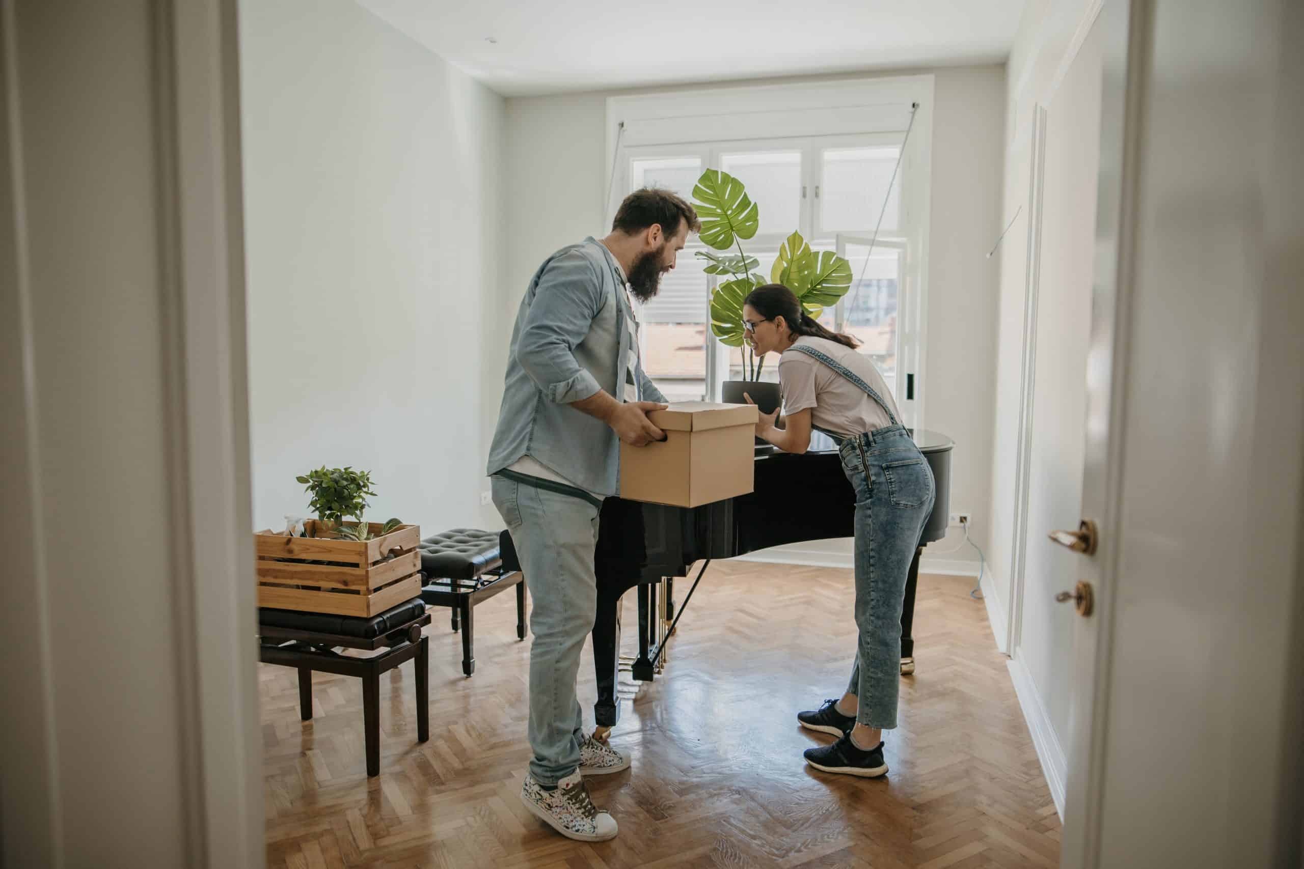 couple in new apartment close to a piano