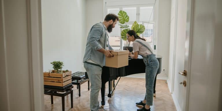 couple in new apartment close to a piano